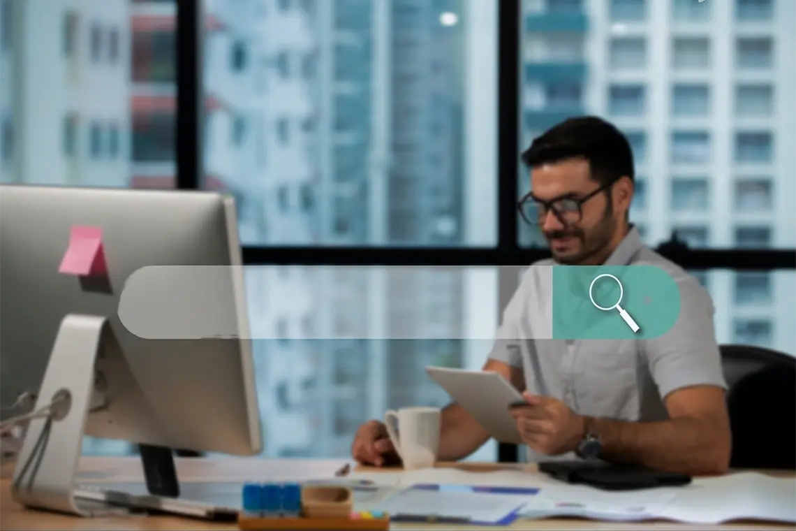 El joven profesional, revisando los resultados de las estrategias de marketing en su PC y tablet al mismo tiempo.