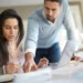 Mujer sonriente y hombre concentrado trabajando en equipo para optimizar la velocidad de carga y SEO de un sitio web peruano.