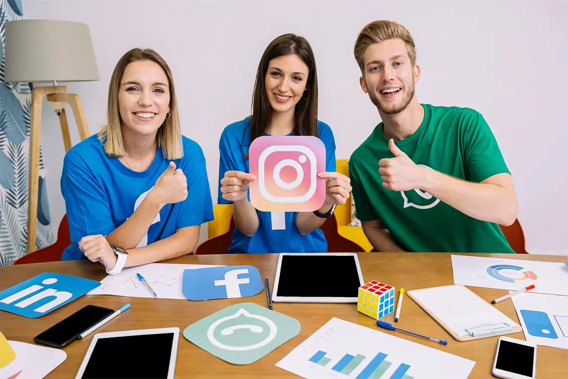 Tres profesionales del marketing digital sonrientes, con el pulgar hacia arriba, aprueban el uso de iconos en las SERPs por sus beneficios en la visibilidad online. 
