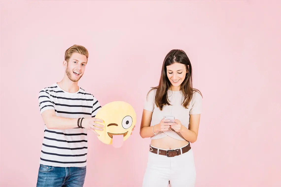 Un joven con un emoji de almohada y una chica con su celular, analizan el CTR local y su impacto en el posicionamiento SEO de las empresas locales en Arequipa.