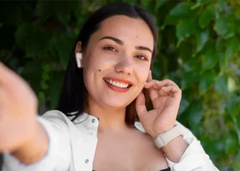 Una joven influencer sonriente, con su celular en mano, inicia una transmisión en vivo para conectar con su público local y compartir su experiencia sobre el SEO local en el mercado peruano.