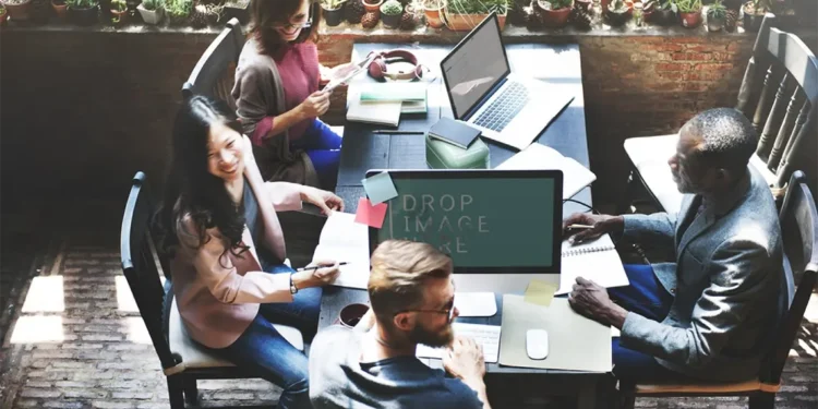 Un equipo de marketing en una oficina moderna, con un joven de barba en el centro conversando con una mujer sobre la importancia de la analítica web.