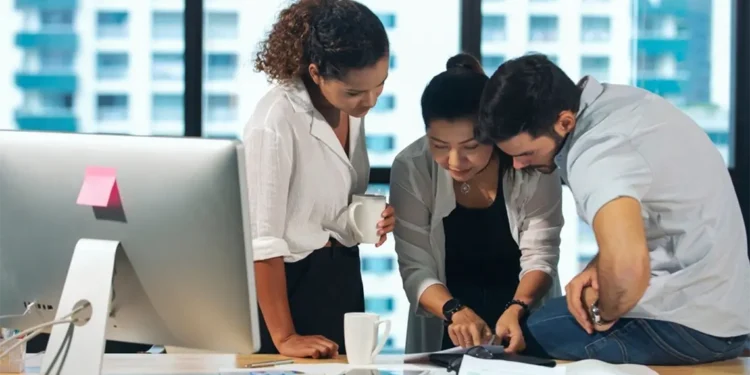 Un equipo de marketing en una oficina moderna, revisando una imagen en papel y discutiendo estrategias de optimización avanzada de imagenes.