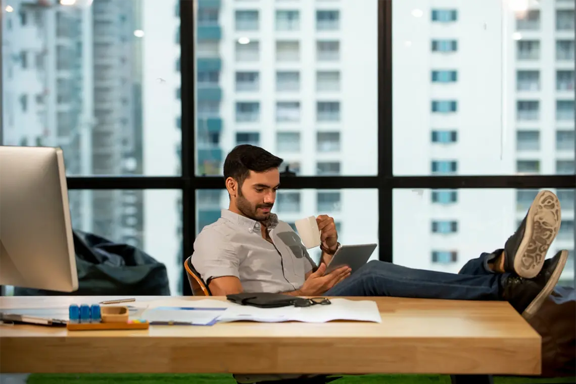 El joven profesional de la foto anterior, ahora se encuentra relajado tomando un café mientras reflexiona sobre las estrategias de marketing.