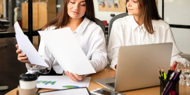 Dos mujeres profesionales analizan un informe de SEO en una laptop, trabajando juntas para optimizar la visibilidad online y las estrategias SEO para empresas en Arequipa