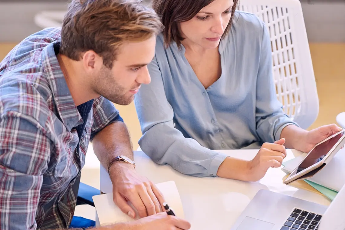 Aumentar el tráfico orgánico con enlaces internos La supervisora, señalando la laptop del marketer, le indica qué acciones tomar para aumentar el tráfico orgánico con enlaces internos.